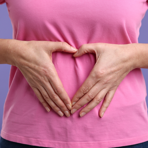 Woman with Healthy Stomach Making Heart Gesture on Purple Background, Closeup